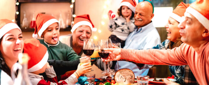 family having christmas feast toasting wine for christmas dinner